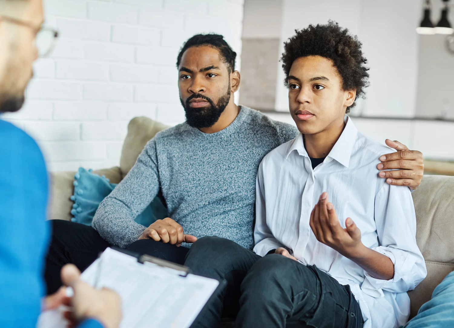 Father with his teenage son at meeting with social worker